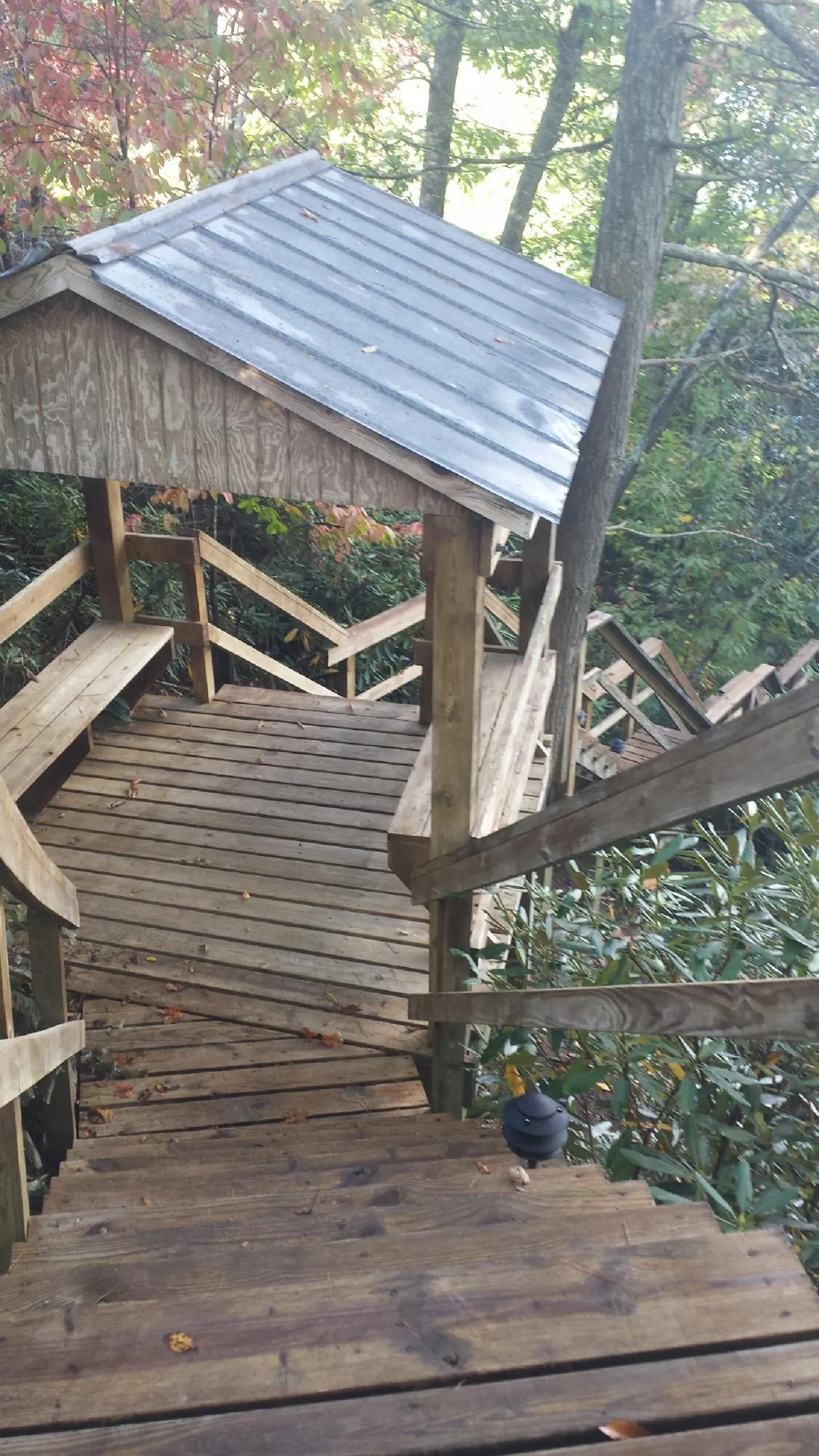 Metal roofed shelter over wooden steps on a wooded walkway — Skylight Repair & Installation work by our crew in Somers